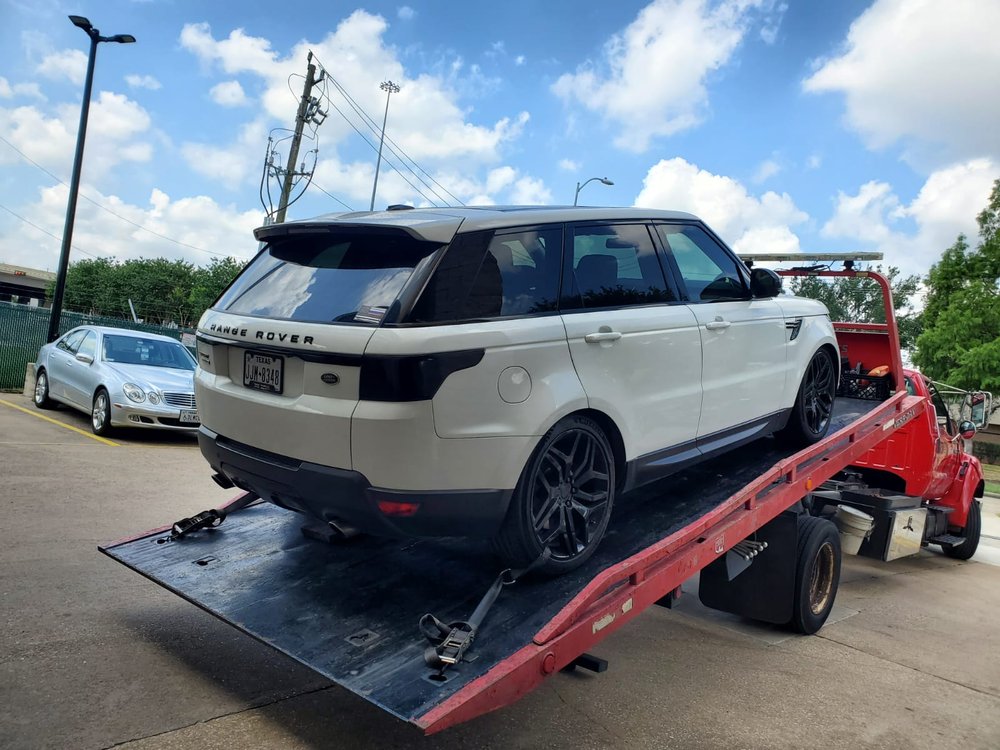 White Range Rover secured on a red flatbed - AA Affordable Towing