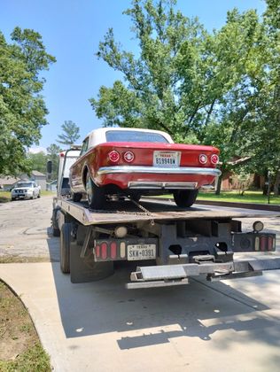 Red classic convertible on a flatbed truck