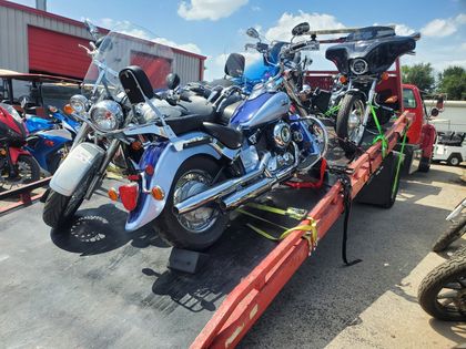 Blue motorcycles strapped down for transport