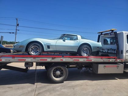 Silver Corvette secured on a flatbed