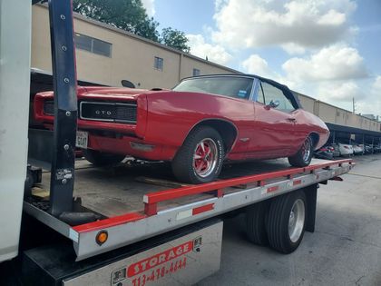 Red classic muscle car on a flatbed