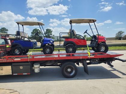 Golf carts secured on a red flatbed