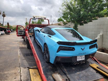 Blue Corvette on a flatbed tow truck