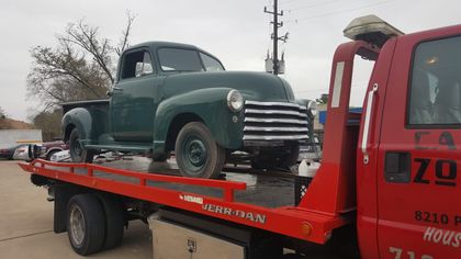 Vintage pickup truck transported on a red flatbed